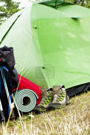 Foto de Equipo de camping de montaña con botas, mochila y tienda de campaña - Imagen libre de derechos