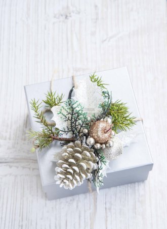 Foto de Regalo de Navidad de plata adornado con cono de pino y abeto - Imagen libre de derechos