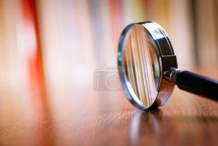 Photo for Close up Single Magnifying Glass with Black Handle, Leaning on the Wooden Table at the Office. - Royalty Free Image