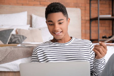 Estudiante afroamericano con portátil que estudia online en casa Estudiante afroamericano con portátil que estudia online en casa