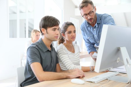 Photo for Teacher with group of students in class working on desktop - Royalty Free Image