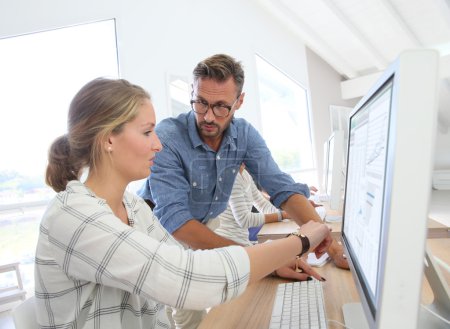 Photo for Student girl with teacher working on desktop computer - Royalty Free Image