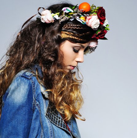 Foto de Retrato de moda de una hermosa mujer joven con peinado gitano con declaración hecha a mano corona de flores y traje de vaqueros de moda - Imagen libre de derechos