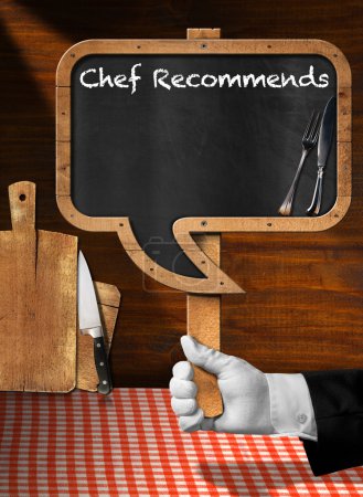 Photo for Hand of chef with white glove holding a pole with empty blackboard in the shape of speech bubble with text Chef Recommends - Royalty Free Image