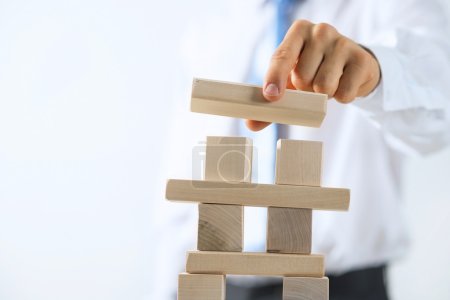 Photo for Close up of businessman building tower of wooden blocks - Royalty Free Image