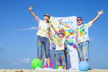 Photo for Happy family with paint  playing on the beach at the day time. Concept of friendly family. - Royalty Free Image