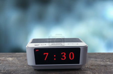 Téléchargez les photos : Horloge numérique montrant 7 : 30 heures sur table en bois, fond de nuit - en image libre de droit