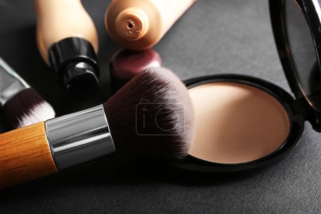 Foto de Maquillaje de cepillos y cimientos sobre fondo gris - Imagen libre de derechos