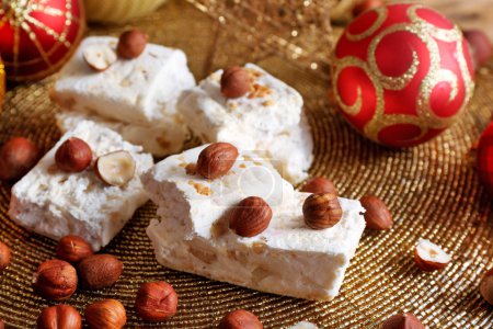 Turrón dulce con avellanas y mesa de decoración de Navidad de cerca
