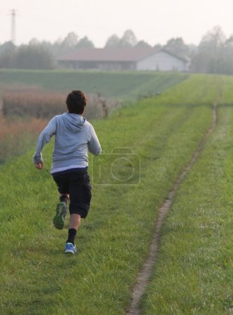 niño corre a lo largo de una carretera
