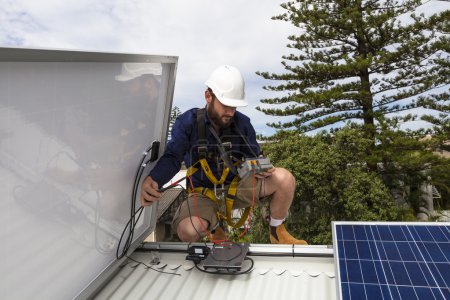 Foto de Técnico de panel solar midiendo la producción solar en el techo - Imagen libre de derechos