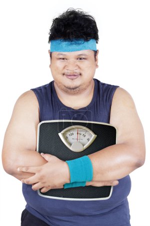 Photo for Portrait of asian person with overweight body holding weight scale, isolated on white background - Royalty Free Image