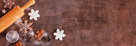Navidad hornear borde de la esquina con galletas de jengibre. Vista superior sobre un fondo de banner de piedra oscura con espacio para copiar. Concepto de vacaciones para hornear.