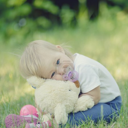 Photo for Cute baby with blue eyes hugging a mascot. - Royalty Free Image