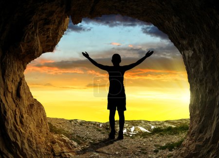 Girl standing in front of the entrance to the cave