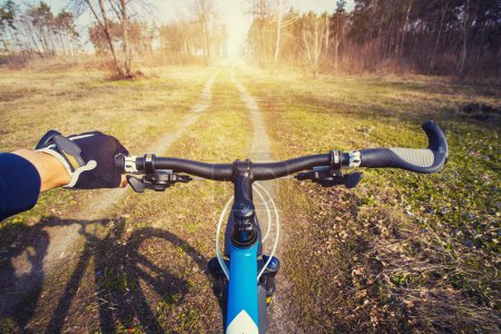 Foto de Ciclismo de montaña colina abajo descendiendo rápido en bicicleta. Vista desde los ojos de los ciclistas. - Imagen libre de derechos