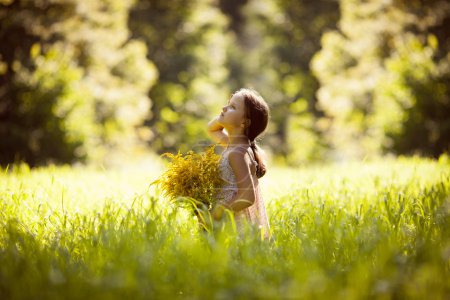 Little girl standing with a bouquet of yellow flowers