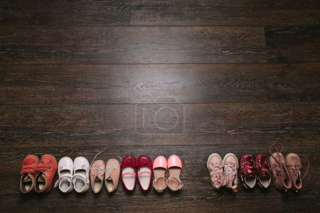 Photo for Old worn baby (child, kid) shoes on the floor. sandals, boots, slippers, sneakers top view. flat lay - Royalty Free Image