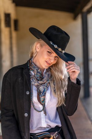 Una hermosa modelo rubia vestida como una vaquera disfrutando del clima al aire libre Una hermosa modelo rubia vestida como una vaquera disfrutando del clima al aire libre