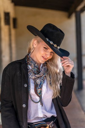 A gorgeous blonde model dressed as a cowgirl enjoying the outdoor weather