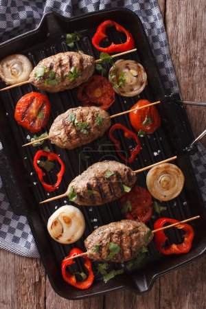 kebab with grilled vegetables on the grill pan close-up. vertica