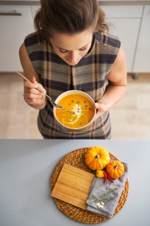 Nahaufnahme einer jungen Hausfrau beim Essen von Kürbissuppe