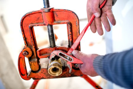 Photo for Industrial plumber using adjustable wrench for copper pipes instalation - Royalty Free Image