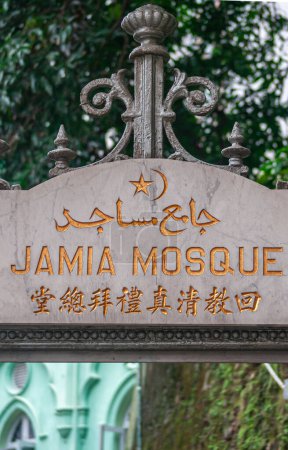 Isla de Hong Kong, China - 14 de mayo de 2010: Primer plano de escritura dorada sobre mármol blanco-gris en 3 idiomas que marcan la entrada a la Mezquita Jamia. 