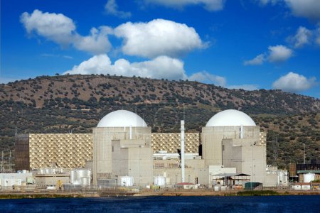 Foto de Central nuclear debajo de un increíble cielo azul con nubes onduladas - Imagen libre de derechos