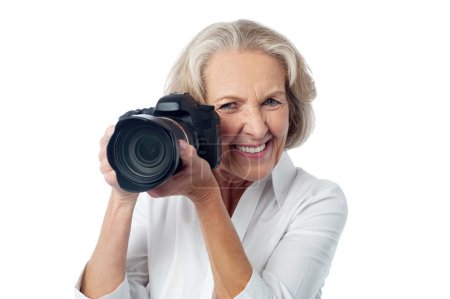 Foto de Mujer mayor tomando fotos con cámara réflex digital, aislado sobre fondo blanco - Imagen libre de derechos