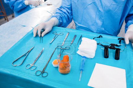 Surgeon with surgical tool on tray 