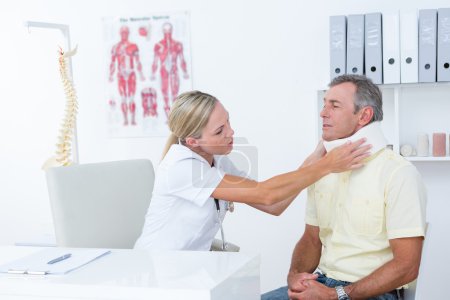 Doctor hablando con el paciente con corsé en el cuello
