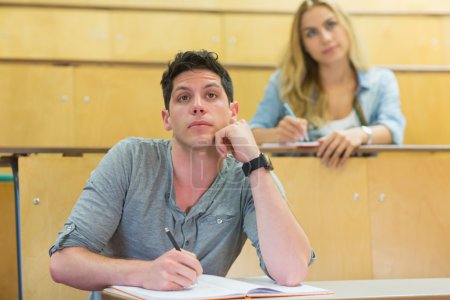 Estudiante masculino reflexivo durante la clase
 