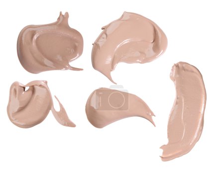 Différents traits de poudre liquide de maquillage sur fond blanc
