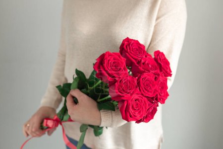 Mujer sosteniendo fresco ramo de flores en flor de rosas rojas. Copiar espacio Mujer sosteniendo fresco ramo de flores en flor de rosas rojas. Copiar espacio