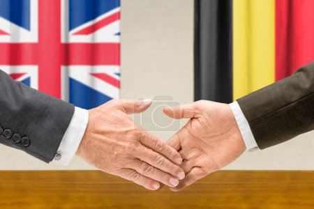 Representantes del Reino Unido y Bélgica se dan la mano
