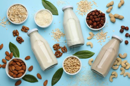 Photo for Different vegan milks and ingredients on light blue background, flat lay - Royalty Free Image