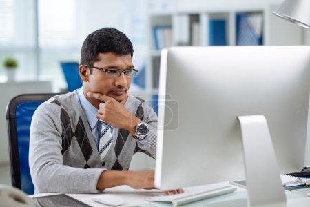 Photo for Unhappy Indian programmer looking at computer screen - Royalty Free Image