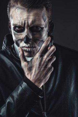 Retrato del hombre pensativo con cráneo de maquillaje
