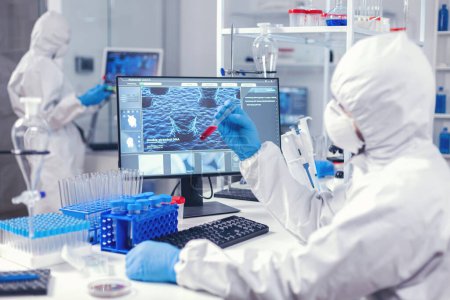 Foto de Equipo de ingenieros médicos analizan la sangre para encontrar una cura para el coronavirus en el laboratorio de ciencias. Médico que trabaja con diversas bacterias y tejidos, investigación farmacéutica para antibióticos contra el covid19. - Imagen libre de derechos