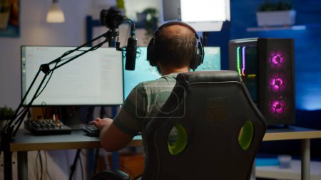 Volver tiro del hombre streamer jugando en el poderoso videojuego shooter ordenador Volver tiro del hombre streamer jugando en el poderoso videojuego shooter ordenador