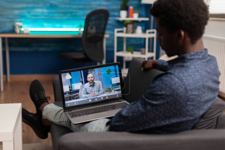 Estudiante afroamericano teniendo seminario web de la escuela de administración en línea