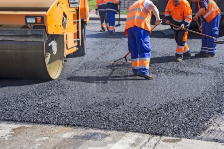 Foto de Rodillo y trabajadores sobre asfalto y reparación de calles de la ciudad - Imagen libre de derechos