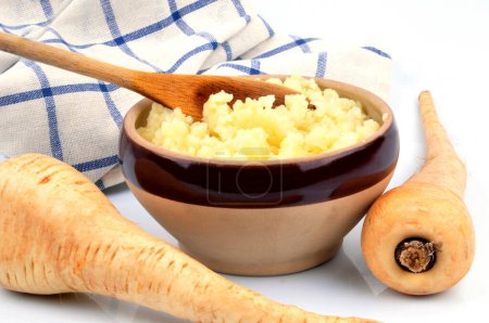 Photo for Bowl of parsnip puree with wooden spoon and kitchen towel close-up - Royalty Free Image