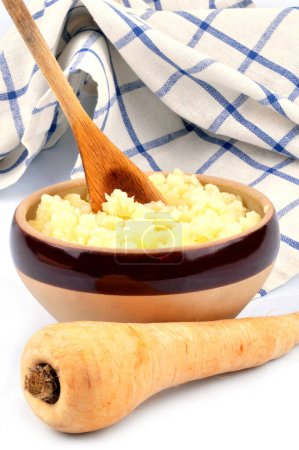 Photo for Bowl of parsnip puree with wooden spoon and kitchen towel close-up - Royalty Free Image