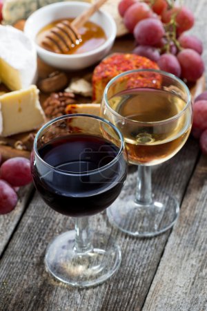 Copa de vinos blancos y tintos, aperitivos en una mesa de madera
