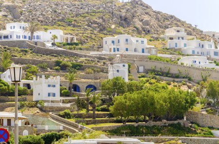 Téléchargez les photos : Le cube blanchit à la chaux maisons traditionnelles et moulin à vent à Ornos, Mykonos, Grèce. Architecture insulaire grecque très typique sur une colline rocheuse
. - en image libre de droit