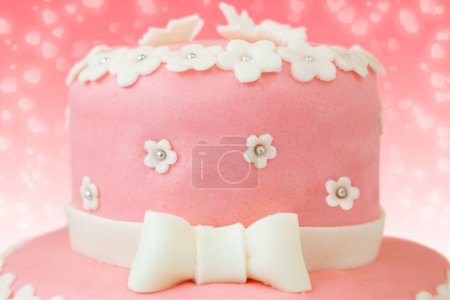 Pastel rosa con decoración de flores y mariposas
