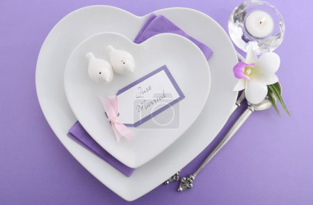 Photo for Purple theme wedding table place setting with heart shape plates and vintage silverware. - Royalty Free Image