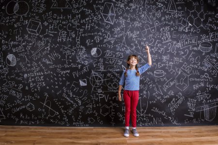 Foto de Linda niña delante de la pizarra grande - Imagen libre de derechos